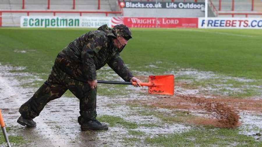 جهود تبذل لتجهيز أرضية الملعب عقب هطول الأمطار