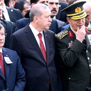 الرئيس التركي رجب طيب أردوغان يتوسط رئيس الوزراء أحمد داوود أوغلو (يسار) وقائد القوات البرية هولوسي أكار (يمين)