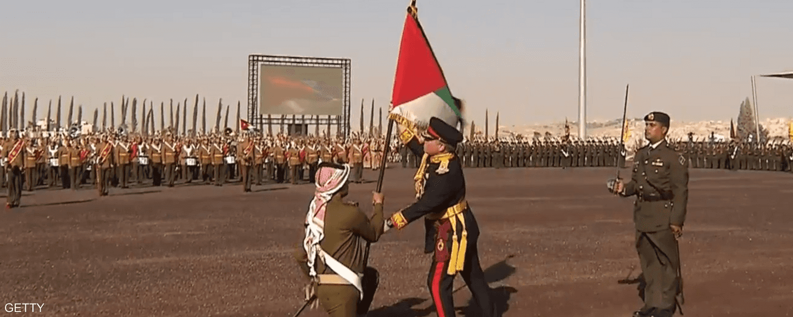 العاهل الأردني، عبد الله الثاني، يسلم العلم في باحة الاستعراض