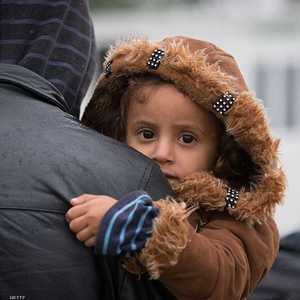طفلة لاجئة في حضن والدتها لدى الوصول إلى اليونان