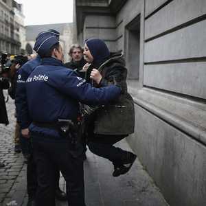 أفراد من شرطة بروكسل يحاولون تهدئه إحدى المشاركات في دقيقة صمت على ضحايا هجمات مارس