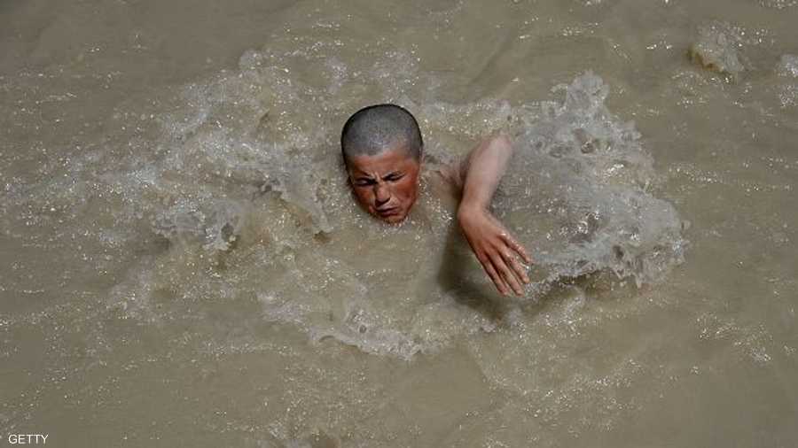طفل فقير يستجم بالسباحة في نهر موحل بأفغانستان