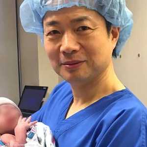 الطبيب المشرف على العملية يحمل المولود الجديد