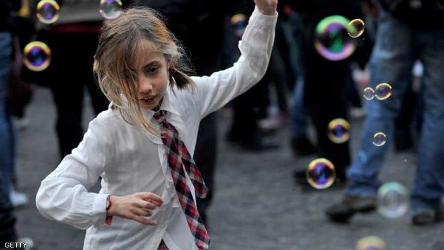 طفلة إيطالية تداعب تلاحق فقاعات الصابون في روما