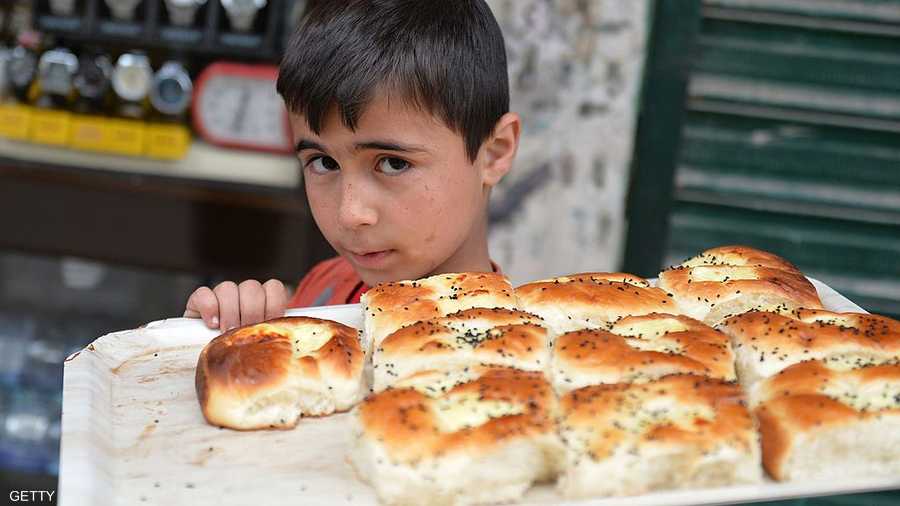 طفل يبيع الكعك في شوارع حرب