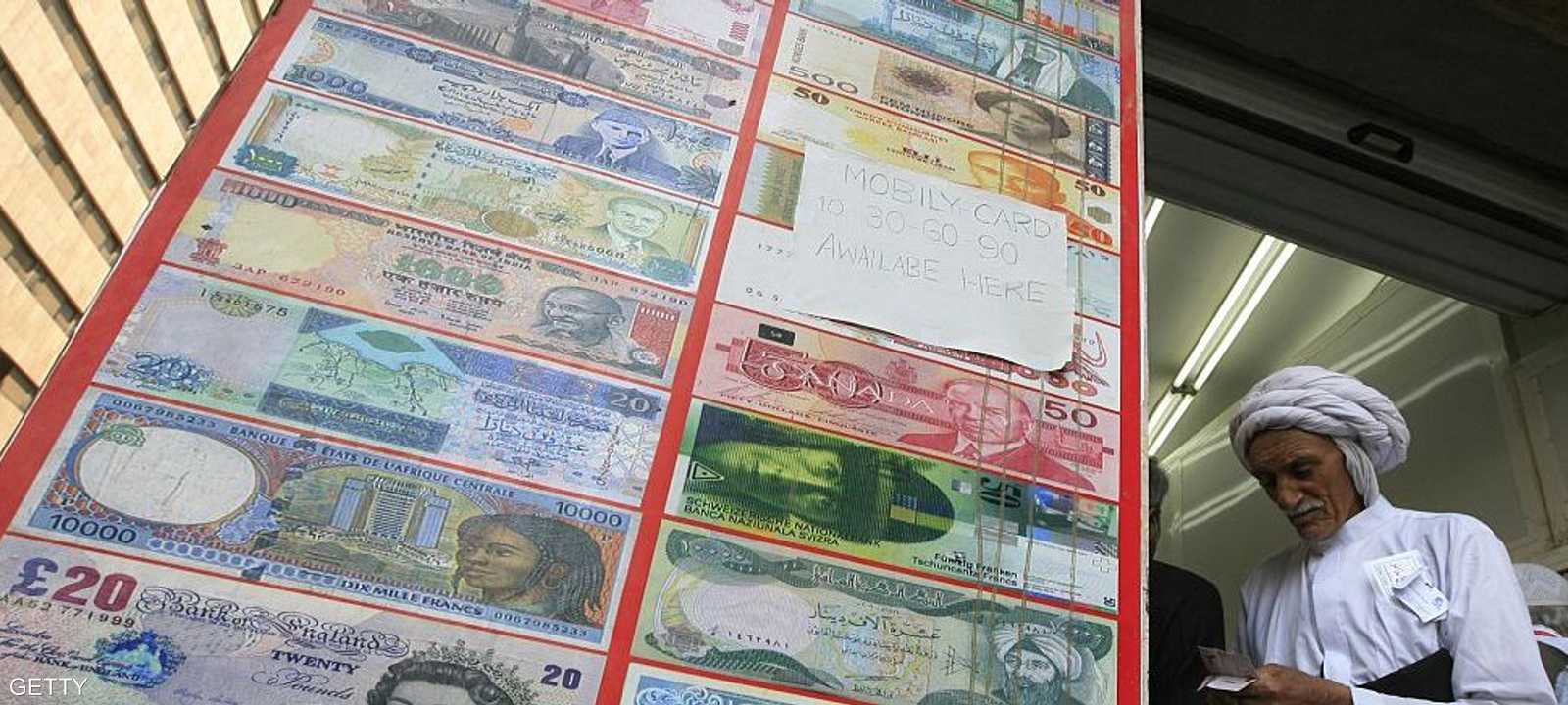 رجل يقف أمام  محل صرافة في مكة المكرمة