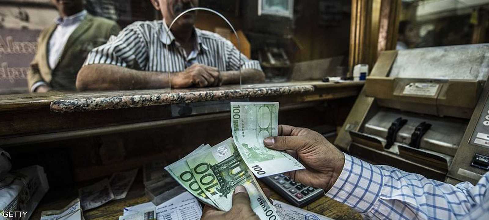 رجل يستبدل نقودا في محل للصرافة بالقاهرة.