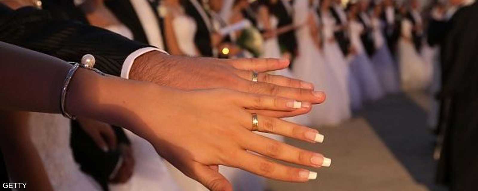 عروس تشهر خاتم الزواج مع يد عريسها