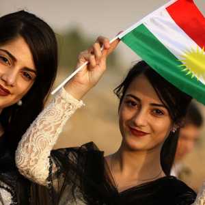 فتيات يحملن العلم الكردي