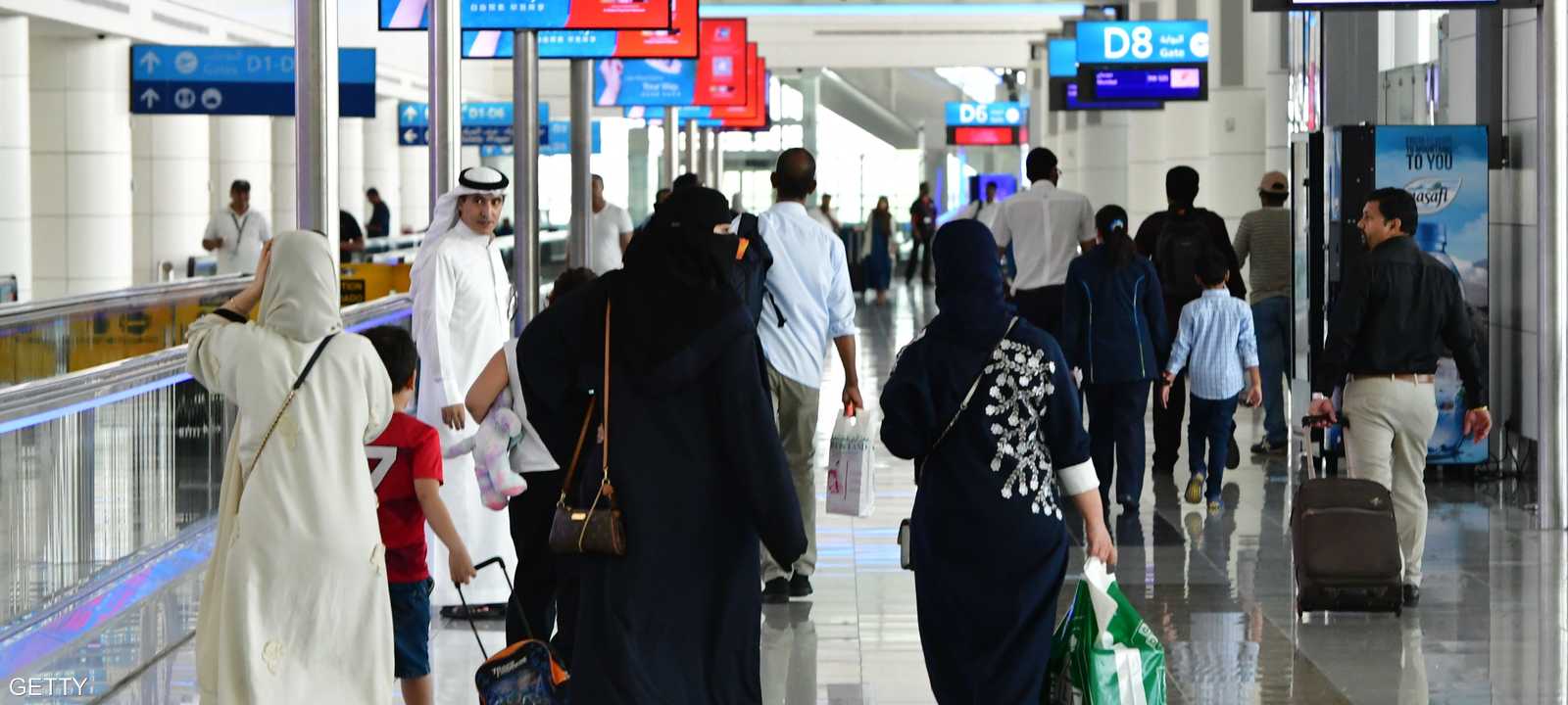 مسافرون في إحدى صالات مطار دبي الدولي.