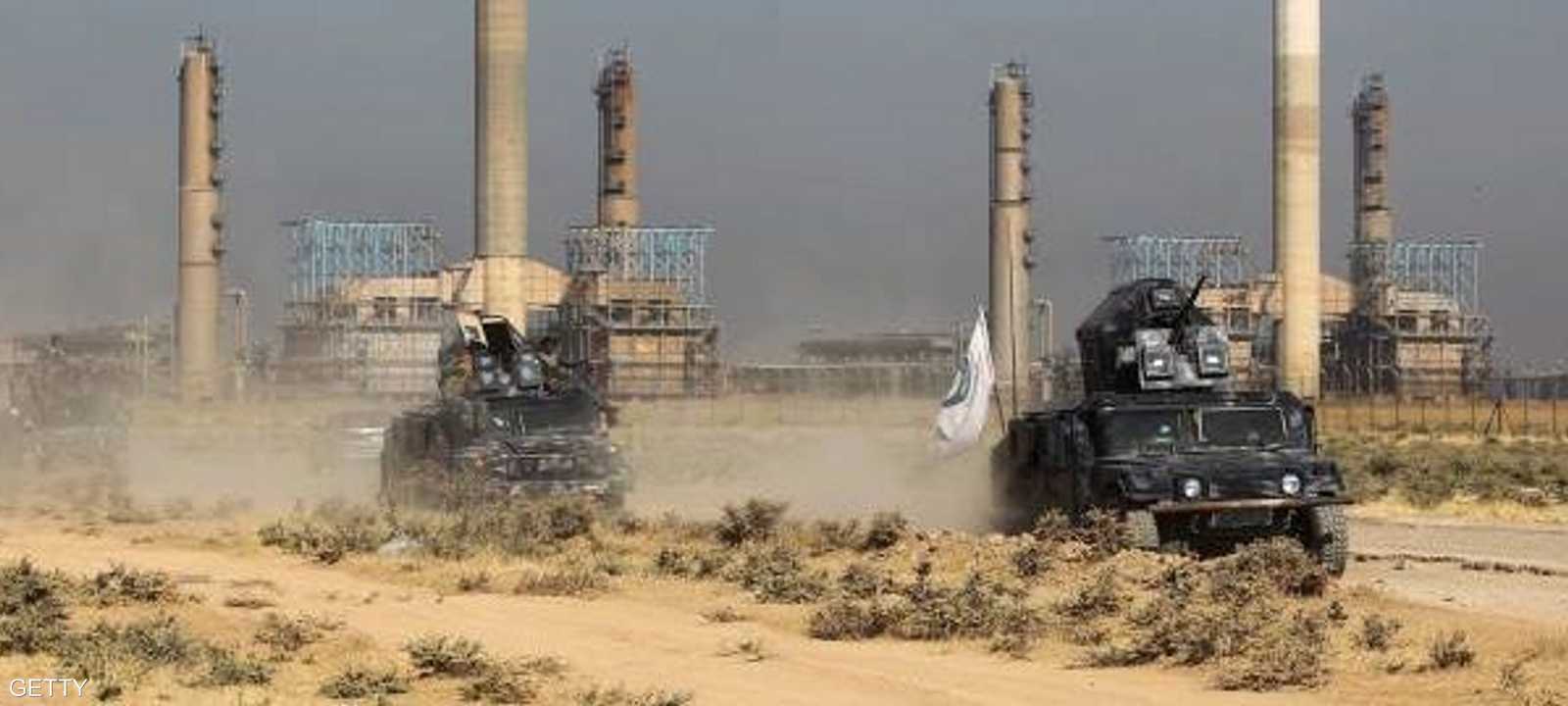 عربات عسكرية للجيش العراقي تمر أمام منشأة نفطية في كركوك.