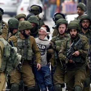 الجنود الإسرائيليون يقتادون الفتى وهو معصوب العينين.