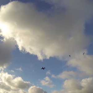 مقاتلة تمر بمحاذاة مظليين