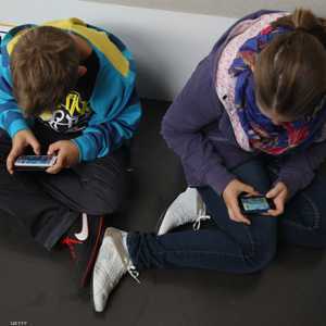 طفلان منشغلان بهاتفيهما