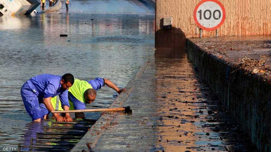 عمال البلدية في الكويت يحاولون تصريف المياه بأحد الشوارع