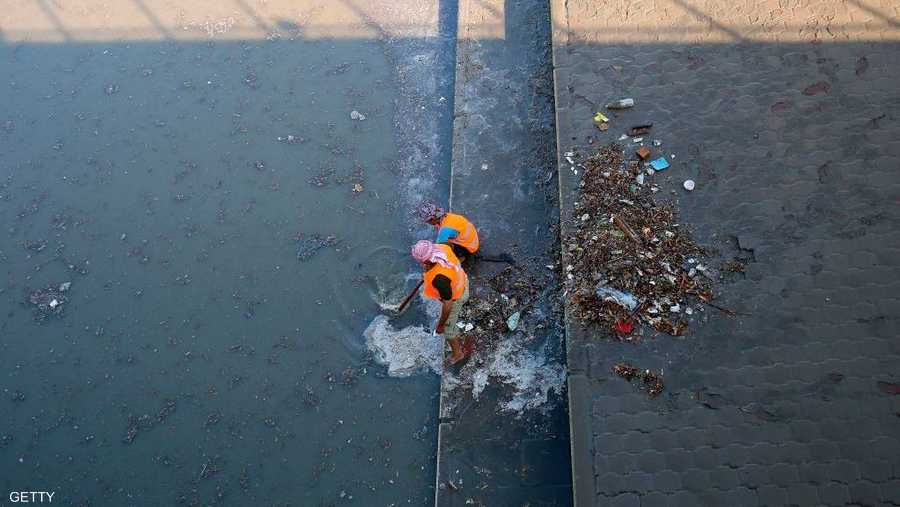 عمال البلدية يحاولون تصريف مياه الأمطار