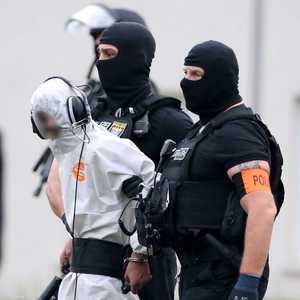 علي بشار محاطا برجال الشرطة الألمانية أثناء اقتياده للسجن