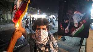 متظاهر غاضب في البصرة يحرق العلم الإيراني وصورة المرشد.أرشيف