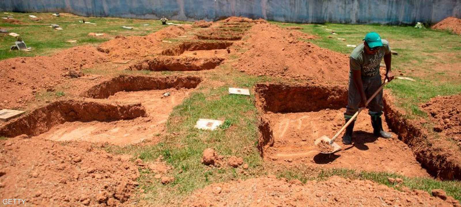 عامل يقوم بحفر قبور لضحايا انهيار السد