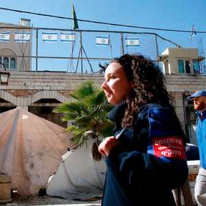 مراقبون دوليون يمرون من أمام بؤرة استيطانية في وسط الخليل