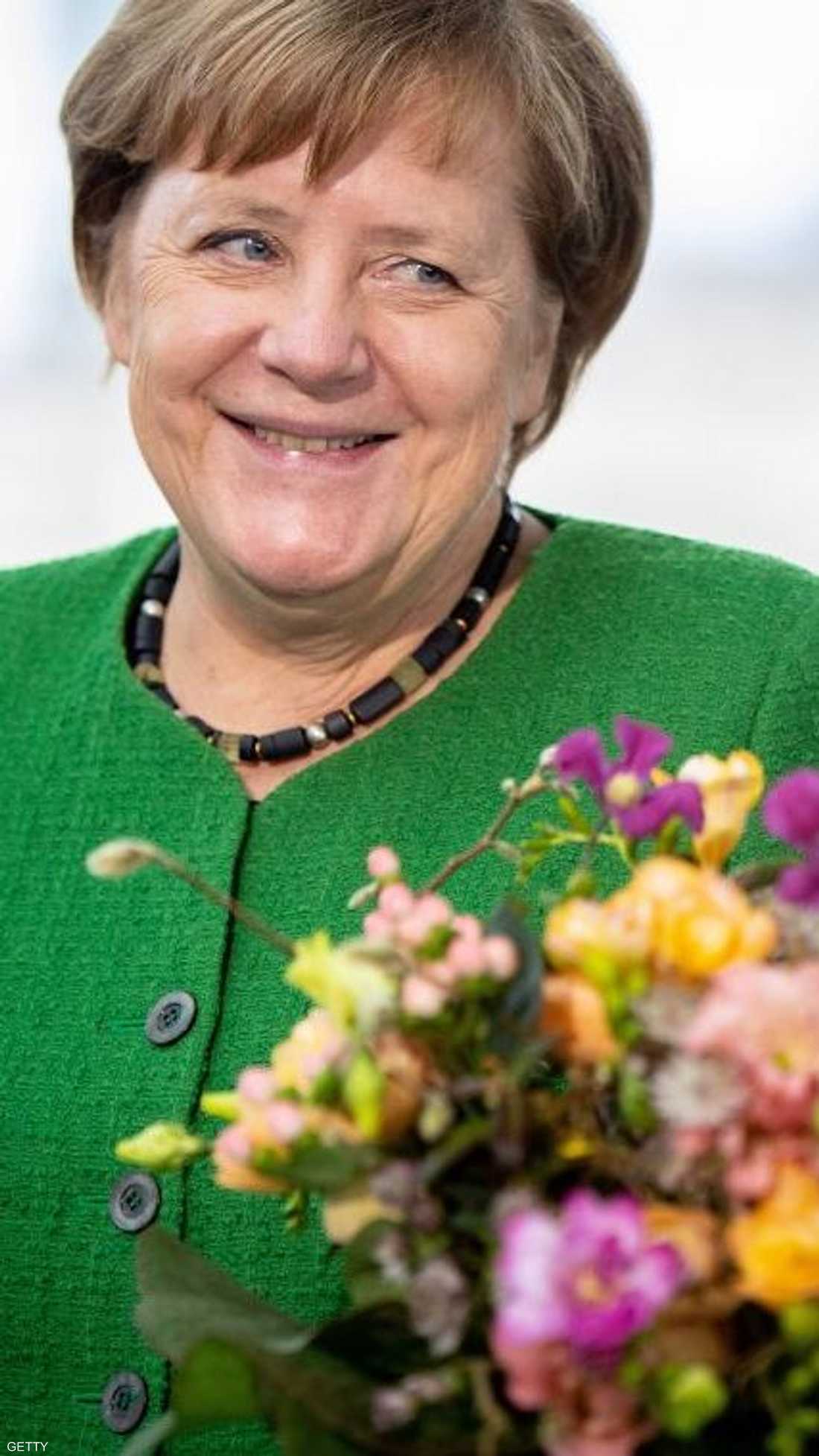 المستشارة الألمانية أنغيلا ميركل تقتني الزهور في عيد الحب