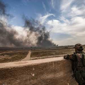 مقاتل سوريا الديمقراطية يراقب الدخان المتصاعد من الباغوز