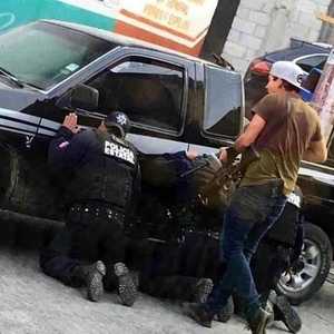 عناصر الشرطة المختطفين يركعون تحت تهديد المسلح