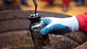 أحد العمال يقوم بجمع عينة من النفط الخام