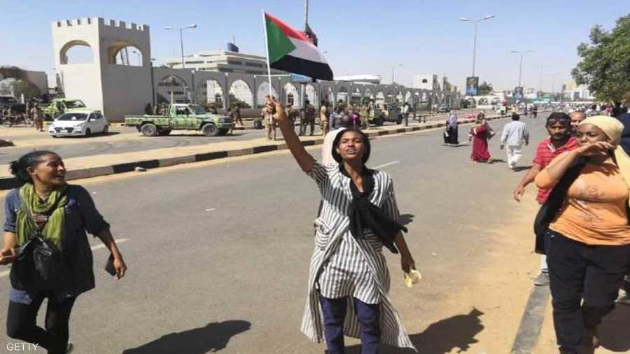 فتاة ترفع علم السودان خلال التظاهرات الاحتجاجية