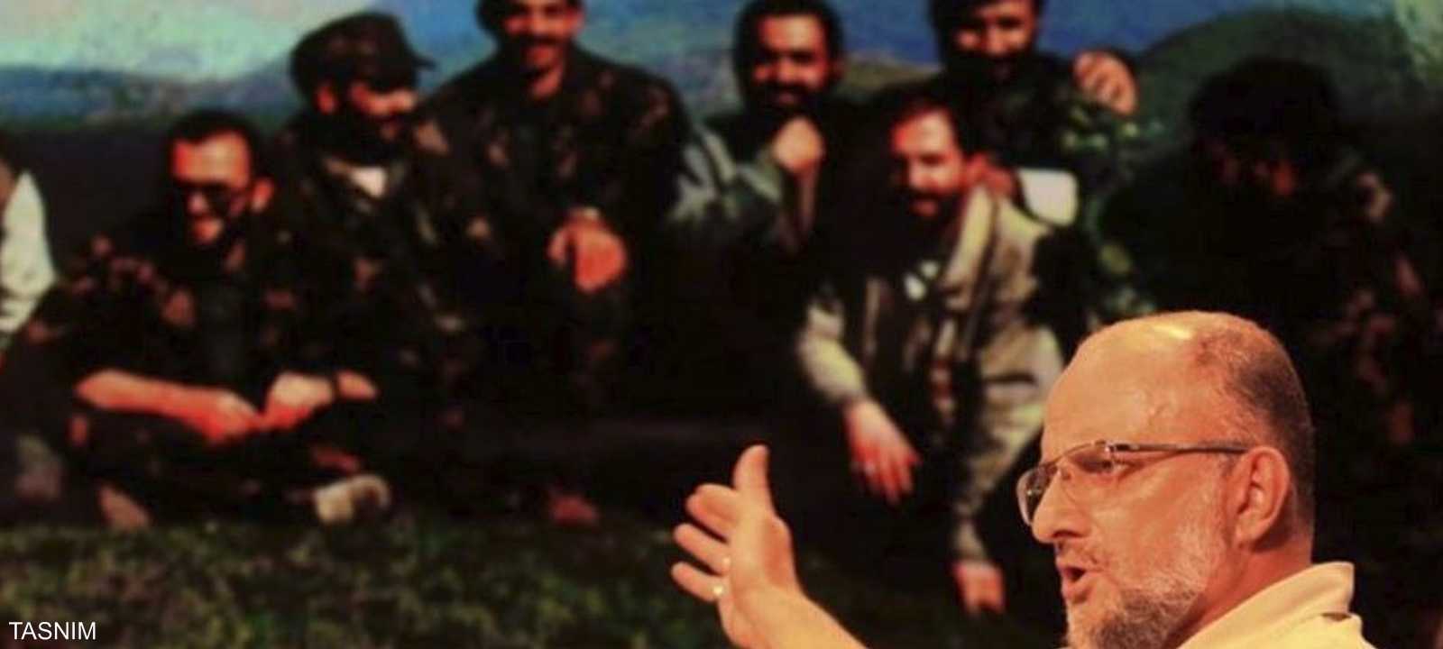 قاسمي يشير إلى صورة تجمعه مع مقاتلين إبان حرب البوسنة