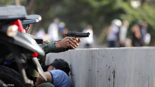 عسكري فنزويلي يشهر سلاحه خلال اشتباكات مع قوات الأمن قرب قاعدة جوية في كاراكاس