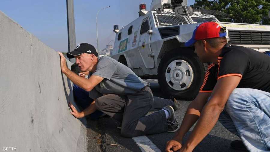 واحتمى عسكريون ومدنيون معارضون بجدار اسمنتي في كاراكاس، بعدما تحولت التظاهرات قرب القاعدة العسكرية إلى اشتباكات مسلحة.