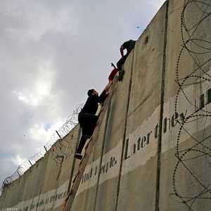 شبان فلسطينيون يحاولون الوصول إلى القدس عبر الجدار.