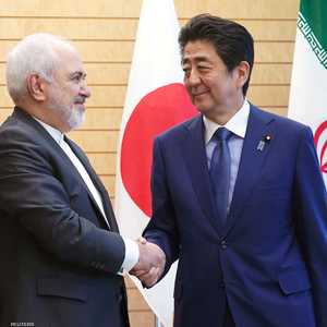 آبي مصافحا ظريف خلال زيارة الأخير لطوكيو في مايو الماضي