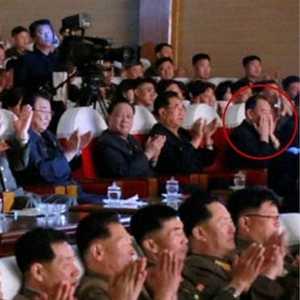 يجلس على بعد خمسة مقاعد جنب كيم جونغ أون ويغطي وجهه بيديه