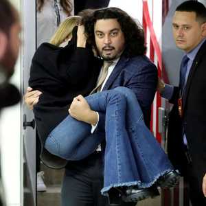 أندرادي يحمل عارضة الأزياء لحمايتها بعد خروجها من المحكمة