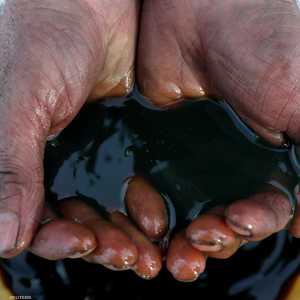 عامل يحمل عينة نفط من حقل إركوتسك الروسي