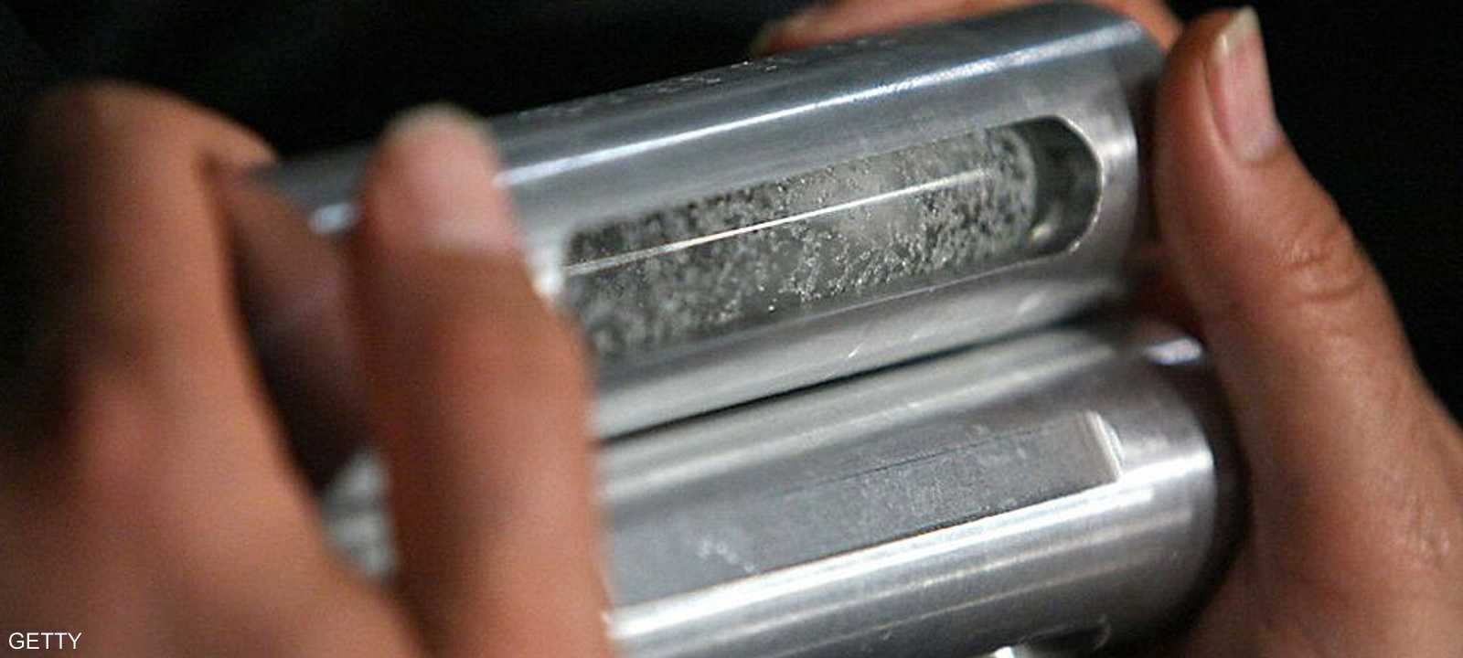 مسؤول إيراني يحمل عينات من اليورانيوم المخصّب