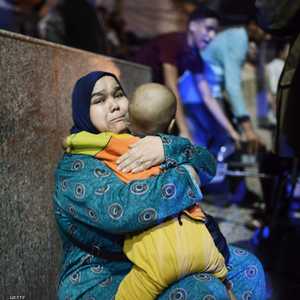 سيدة تحمل طفلها المريض على سلم معهد الأورام بعد الحادث