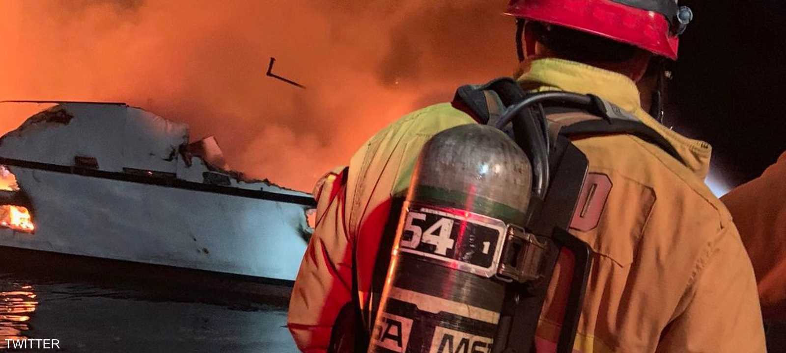 رجال الإطفاء يحاولون احتواء الحريق في السفينة