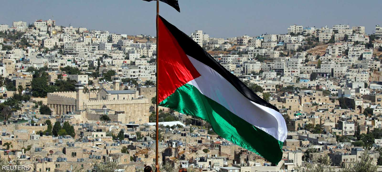 فلسطينيون يرفعون علم فلسطين قبالة الحرم الإبراهيمي