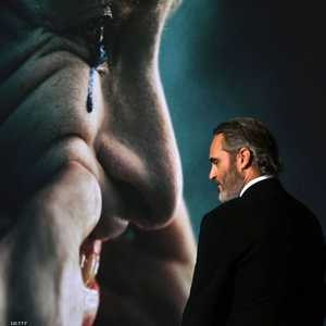 فينكس أمام صورة الجوكر في الفيلم