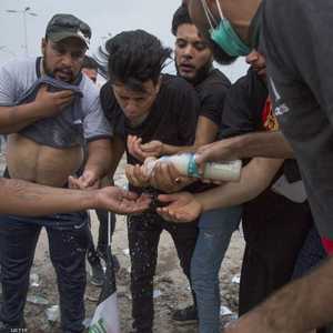 يغسلون وجوههم بعد أن أطلق الأمن الغاز المسيل في البصرة