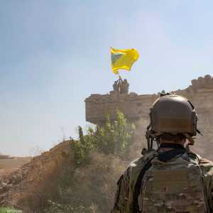 جندي أميركي ينظر إلى عناصر من قوات سوريا الديمقراطية