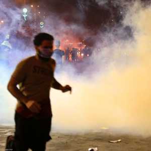متظاهر عراقي يهرب من قنابل الغاز