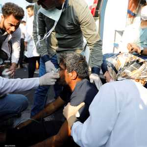 يقدمون العلاج الميداني لعراقي أصيب بمواجهات مع الأمن ببغداد