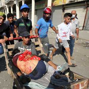محتجون ينقلون أحد الجرحى في بغداد.