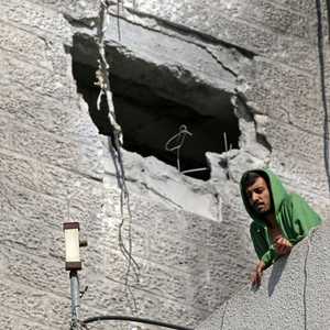 يقف أمام مبنى في مدينة غزة تعرض للقصف الإسرائيلي