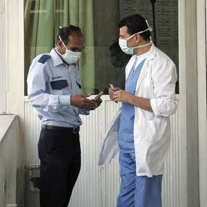 طبيب أردني وموظف يرتديان كمامات في إحدى المستشفيات