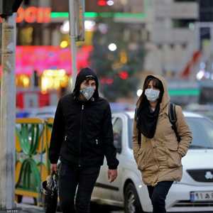 إيرانيان يرتديان كمامتين خوفا من الإصابة بفيروس كورونا